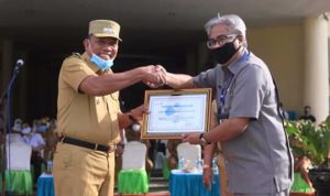 Bupati Bolmut Drs Hi Depri Pontoh saat menerima penghargaan dari Kepala BKKBN Perwakilan Sulut di Bolmut, Ir Tino Tandaju M,Erg
