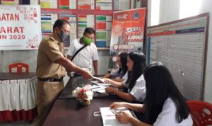 Hukum Tua Desa Kanonang Dua Welly Rawis memberikan masker kepada siswa yang belajar daring di kantor desa Kanonang Dua